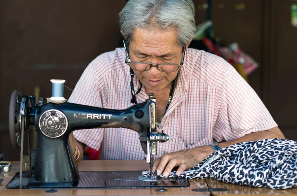 Asian old man Seamstress sewing