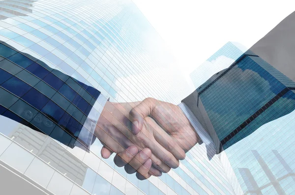 Double exposure handshake between businessmen