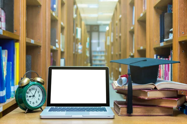 Laptop computer with clock, old books
