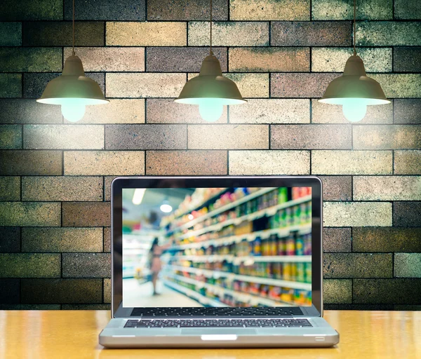 Computer notebook on brick wall background