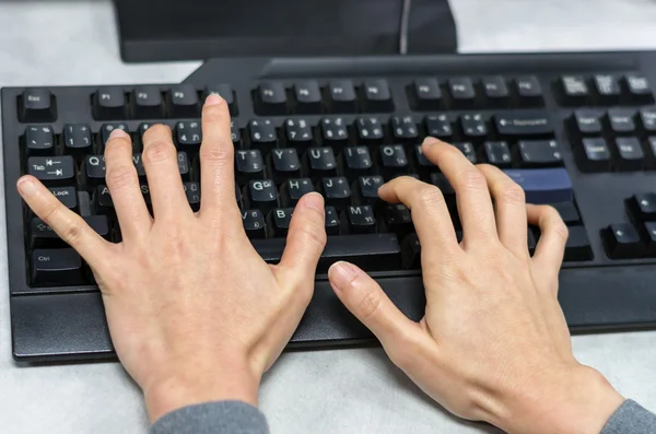 Hands press old keyboard