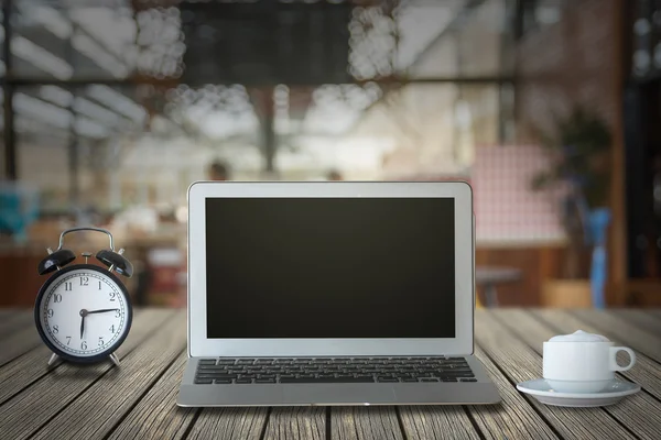Laptop with alarm clock and coffee cup