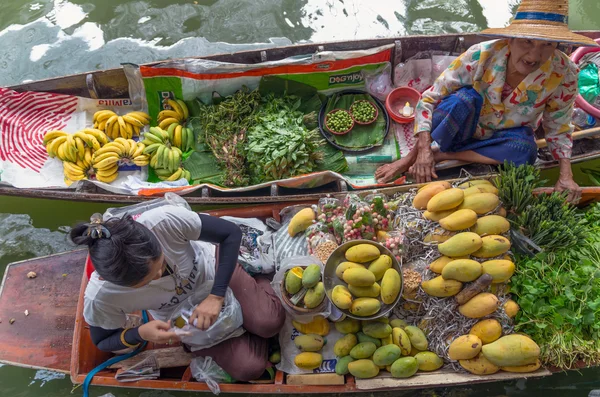 BANGKOK - APRIL 19: Merchant and customer on Wooden boats at Klong Lat Mayom Float Market on April 19, 2014 in Bangkok.