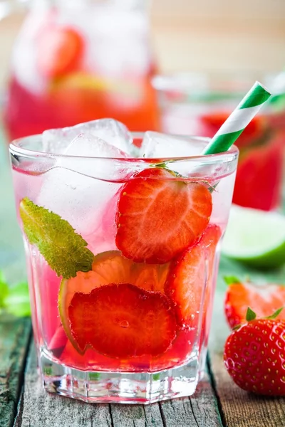 Strawberry lemonade with lime and ice in a glass