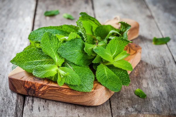 Organic fresh bunch of mint on wooden cutting board