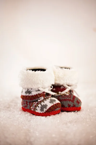 Baby Slippers On Snowy Background