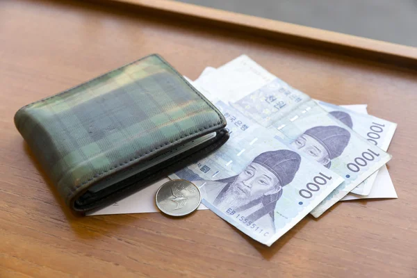Wallet on Korean money on wooden table