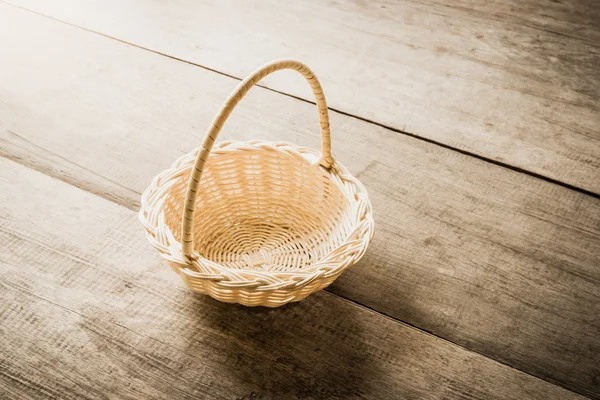 Empty wicker basket on wooden background