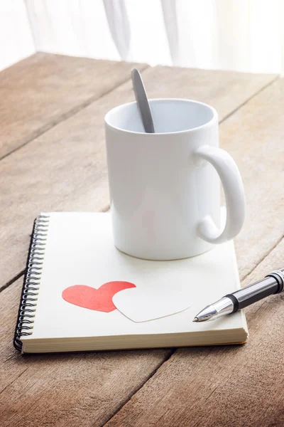 Coffee, red heart, notebook and pen