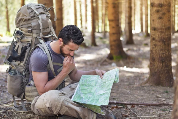 Man with Backpack and map searching directions