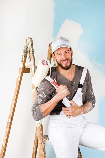 Smiling handsome painter with paint brush