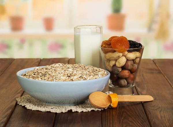 Oatmeal, milk, nuts, dried fruit on  background of  kitchen.