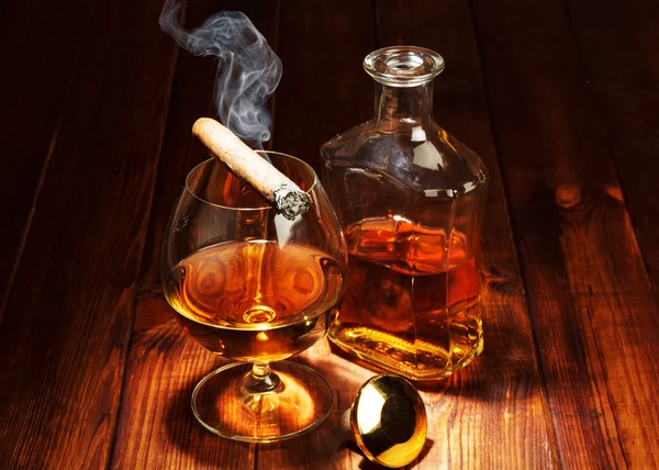 Whisky in glasses and smoking cigar