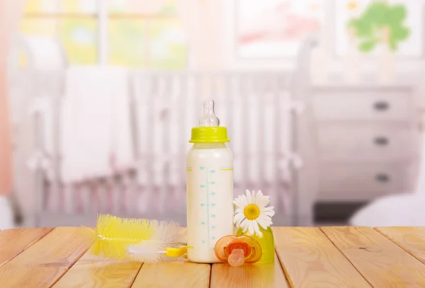 Bottle of milk with  pacifier in  nursery