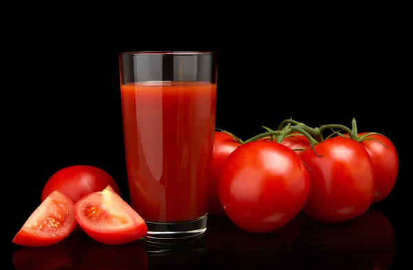 Tomato juice with tomatoes,green twig on black