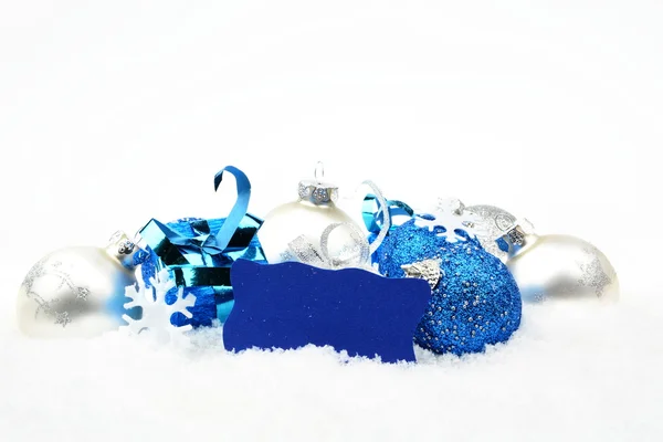 Silver and blue christmas decoration on snow with wishes card