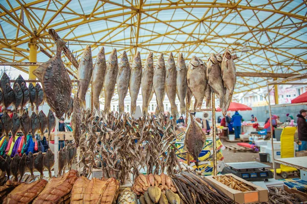 Dried fishes hanged with the ropes in a shop of fish market