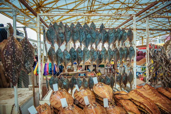 Dried fishes hanged with the ropes in a shop of fish market