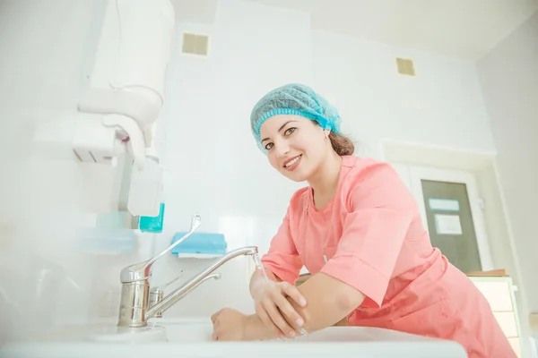 Female surgeon putting on gloves before surgery