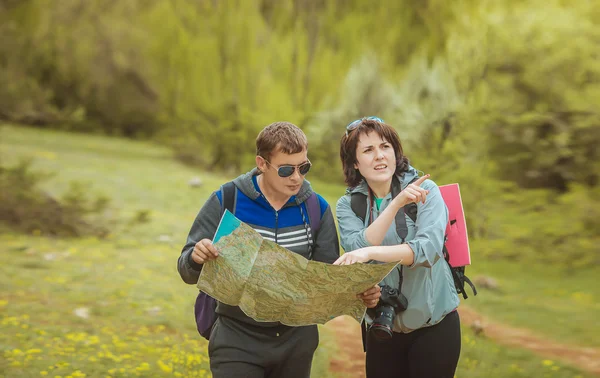 Tourists with a map in the forest