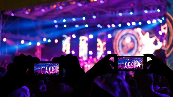 Silhouette crowd in front of concert stage blurred