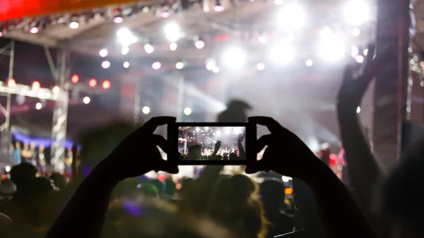 Silhouette crowd in front of concert stage blurred