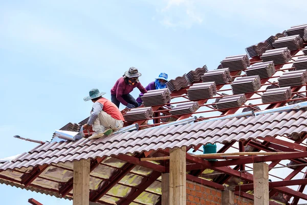 Workers installing roof tile