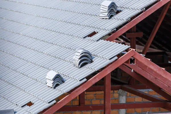 Roof under construction with stacks of roof tiles for home build