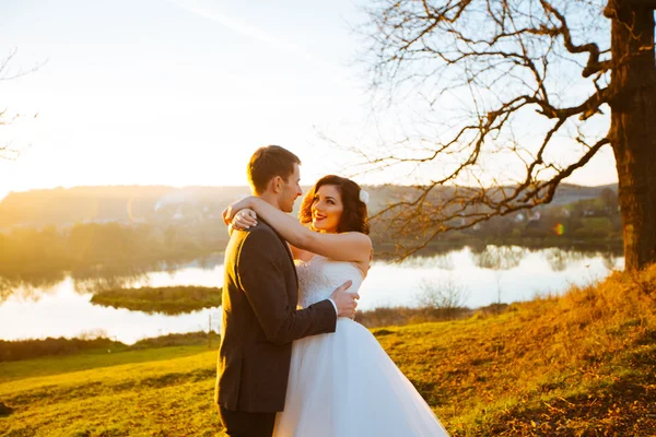 Beautiful couple of happy stylish newlyweds on a walk in the sunny summer park or garden on their wedding day