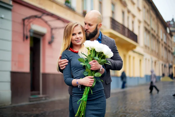 Summer holidays, love, relationship and dating concept - couple with bouquet of flowers in the city