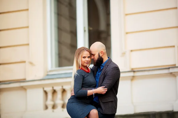 One beautiful stylish emotional couple of young woman and senior man with long black beard embracing sitting close to each other