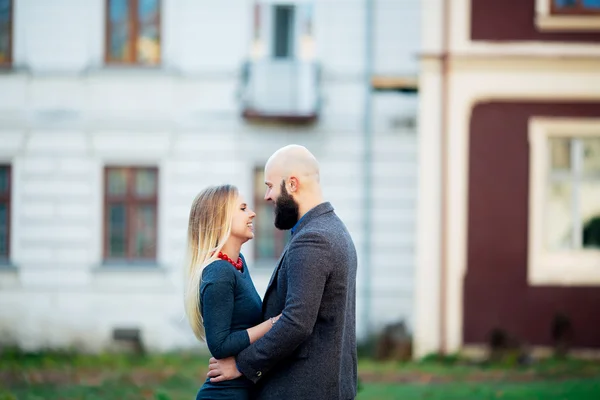 Beautiful young couple in love, hugs, near the ancient building. man in jacket