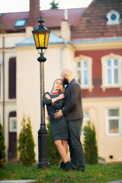 Young fashion elegant stylish couple posing on streets of european city in summer evening weather. Sensual blonde vogue girl with handsome hipster man having fun outdoor.