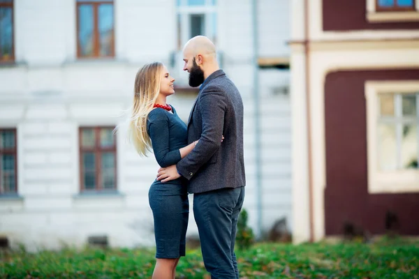 Happy couple in love with each other,One beautiful stylish couple of young woman and senior man with long black beard   embracing close to each other outdoor in autumn street on stairs sunny day