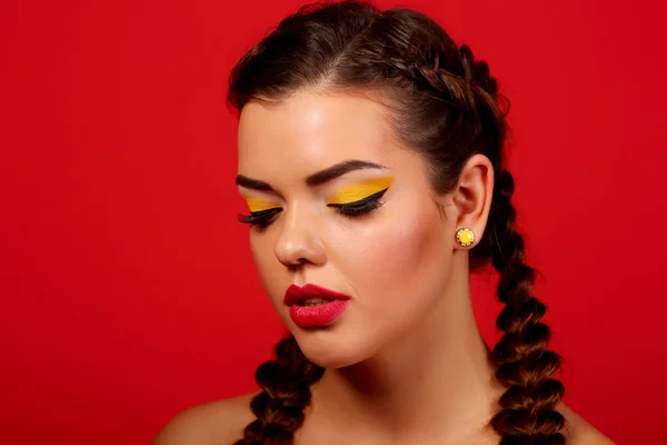 Close-up portrait of beautiful model face with neon bright yellow fashion make-up and with big crystal ring
