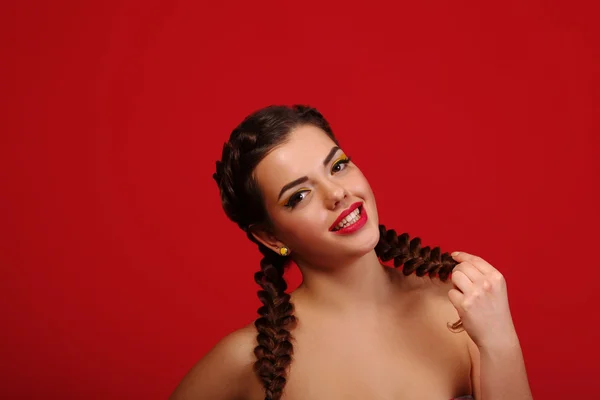 Happy excited woman looking to the side screaming cheerful with wind in the hair on red background. Beautiful multiracial   Caucasian female mode