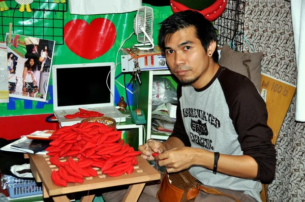 Bangkok, Thailand: Man Sewing Fabric Chili Peppers