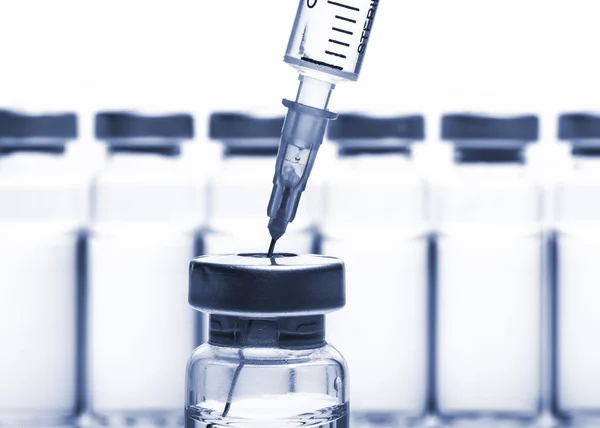 Glass Medicine Vials and Syringe on white background