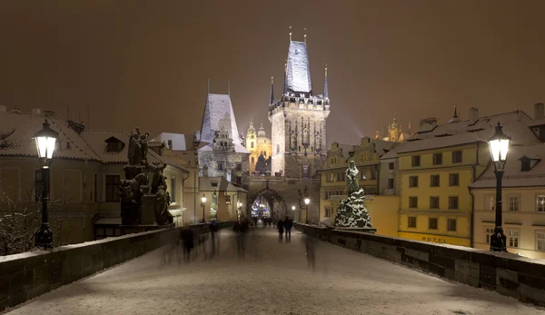 Night romantic snowy Prague Lesser Town with Bridge Tower and St. Nicholas\' Cathedral from Charles Bridge, Czech republic