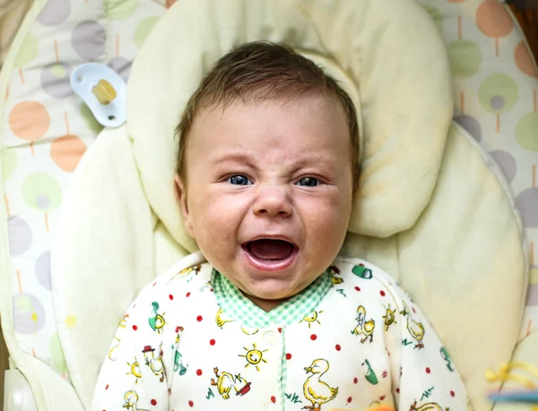 Newborn baby crying in bed