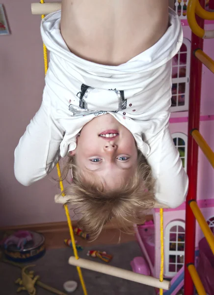 Child hanging upside down on the rings