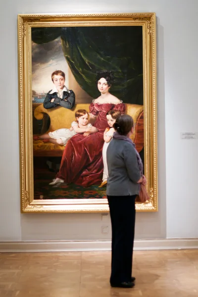 The viewer sees the painting in the museum