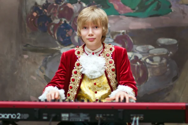 Boy in period costume playing the keyboard