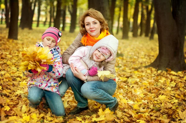 Girls playing with her mother in autumn park