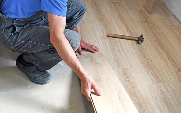 Male carpenter puts the laminate