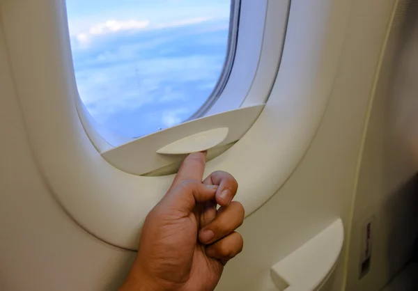 Hand open plane windows with sky outside