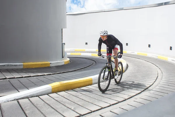 Man professional cyclist races on abstract cycle track