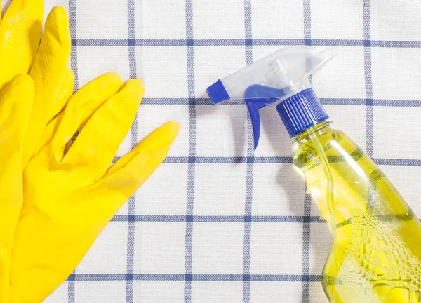 Yellow latex gloves with cleaning spray of detergent