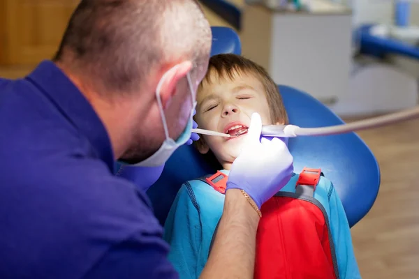 Little child, boy, sitting on a dentist chair, having his yearly