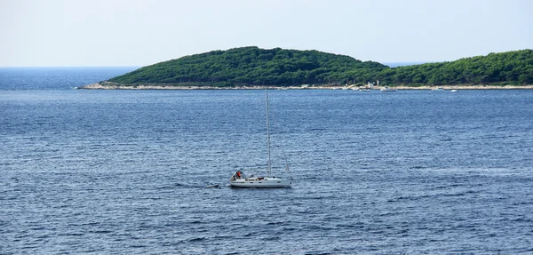 Small Yacht is Sailing Around Island